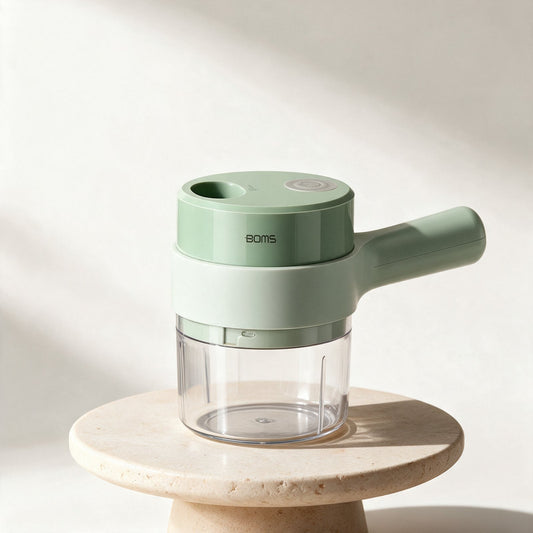 Electric Prep Chopper in pale sage green, standing on a warm stone surface