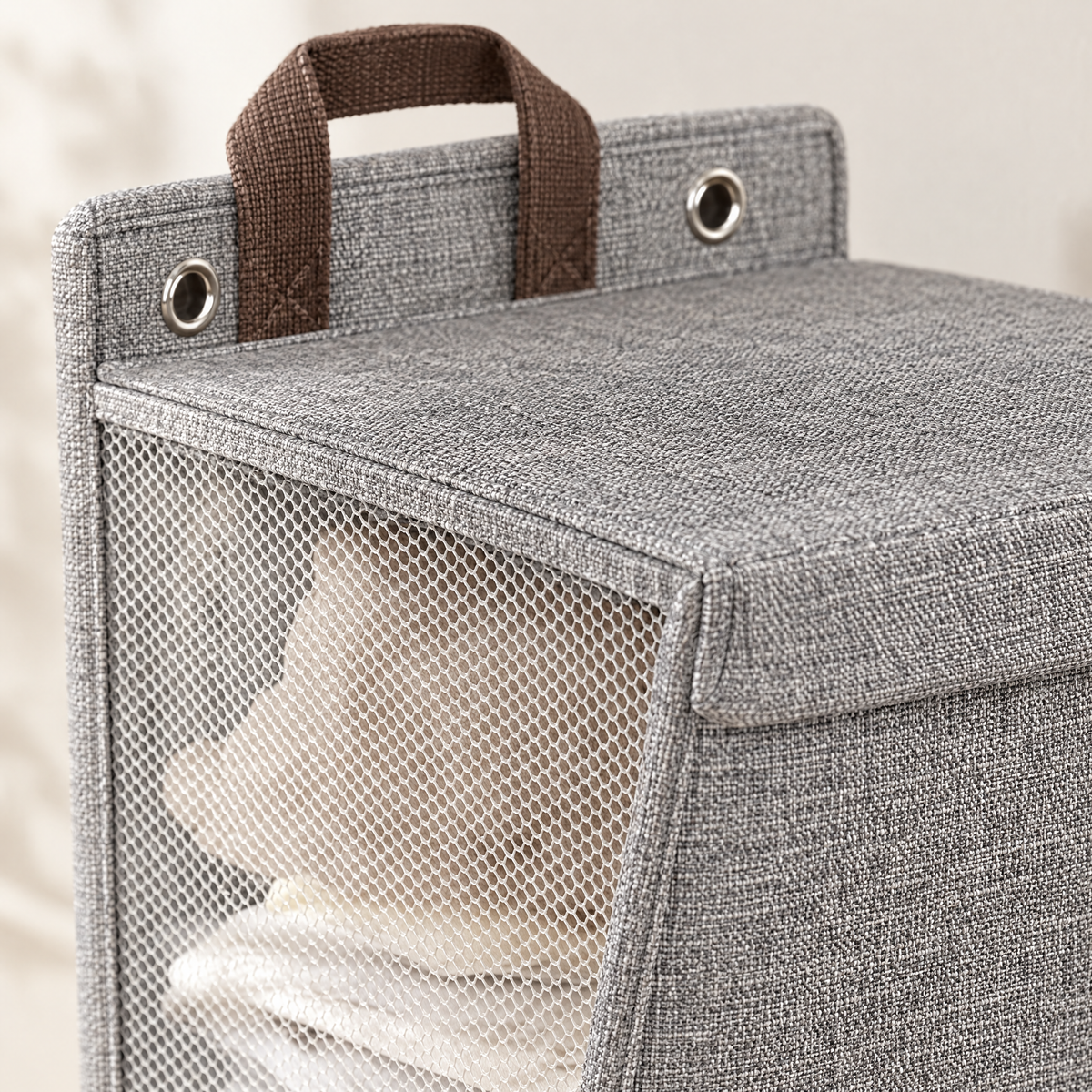 Close-up of linen-look fabric, carry strap, grommet and mesh side panel