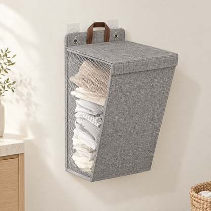 Grey wall-hanging laundry hamper with lid closed, mounted on a warm off-white wall